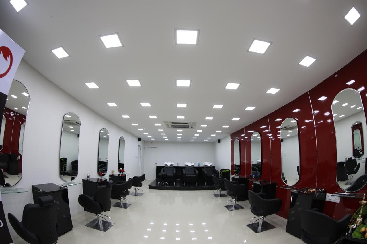Wide view of the HOP Salon styling floor, mirrors down both walls and wash stations at the back