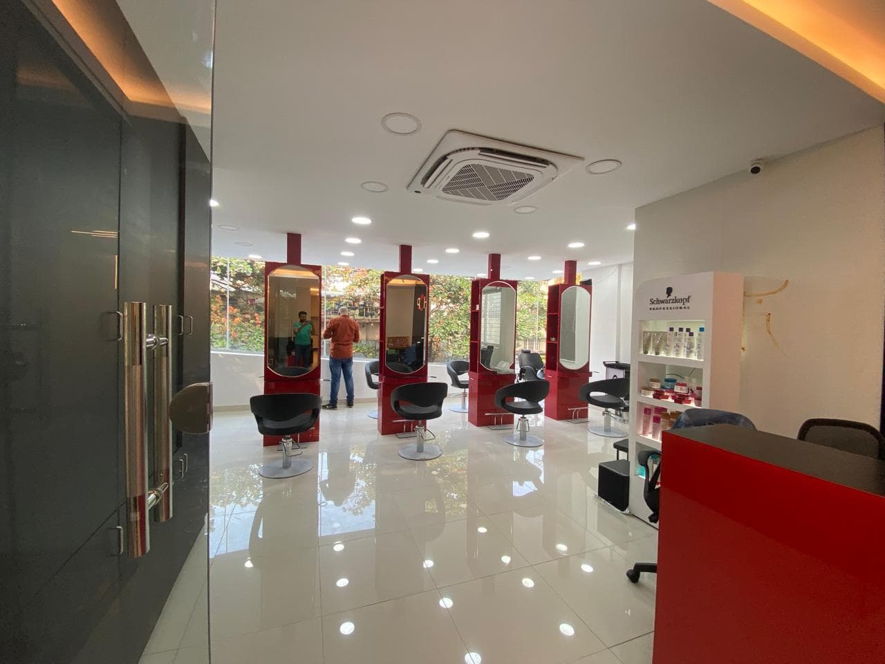 Red styling pods beside a daylit window, with the Schwarzkopf product shelf alongside